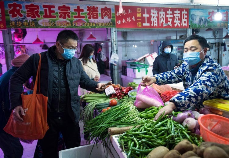 Người dân Vũ Hán mua rau ở chợ. Ảnh: AP.