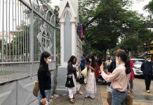 Nhà thờ đóng cửa vì lo ngại dịch virus corona, du khách chụp ảnh trước hàng rào Du khách chụp ảnh nhà thờ Con Gà qua hàng rào. /// ẢNH: NGỌC HÂN