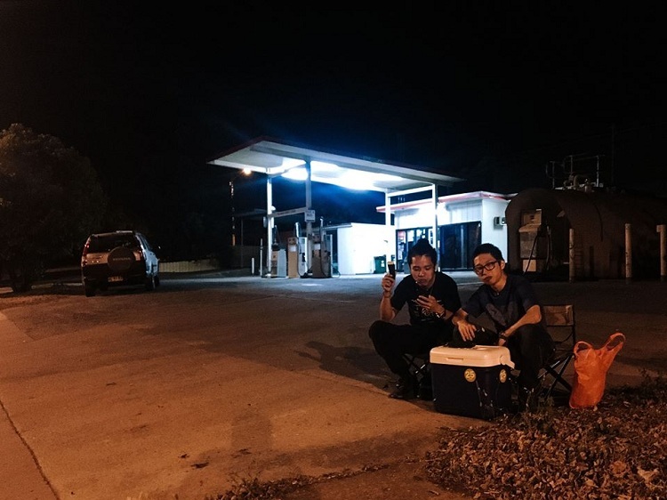 Trần Đức Thái (phải) và Lâm, bạn đồng hành, ăn tối trước trạm xăng đã đóng cửa. Ảnh: NVCC.