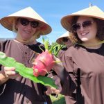 Khách nước ngoài thăm vườn thanh long Chị Viktoryia (phải) cùng các bạn Nga thích thú khi được chạm tay vào trái thanh long. Ảnh: Việt Quốc