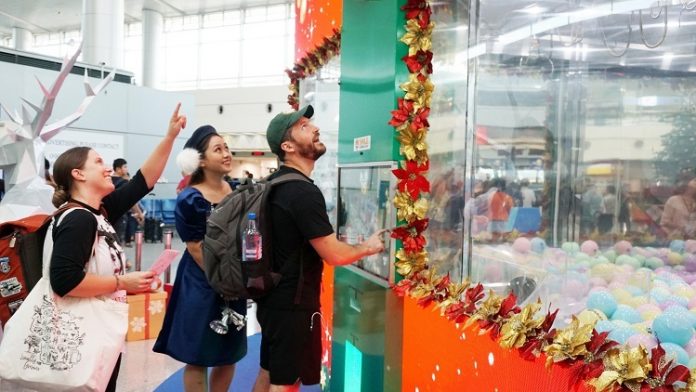 Hành khách nước ngoài thích thú với máy gắp quà tại sân bay Tân Sơn Nhất.