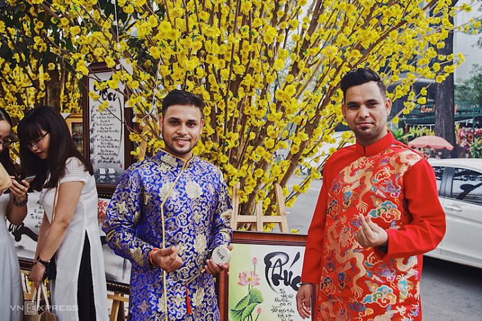 Rajesh (trái) và bạn mặc áo dài đi dạo phố hoa ở Nhà Văn hóa Thanh niên. 