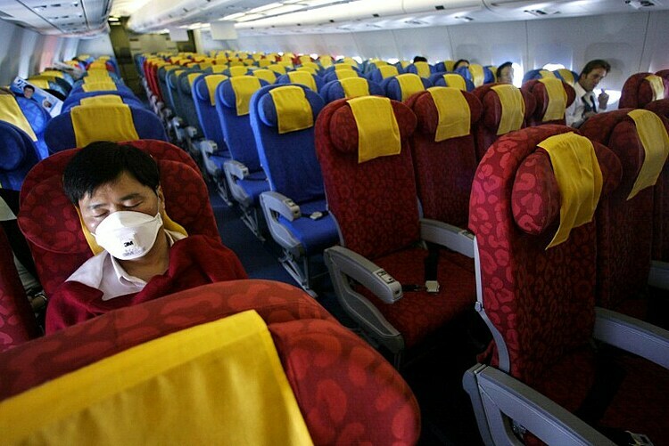 Một hành khách trên chuyến bay gần như trống trơn từ Hồng Kông đến Bắc Kinh vào năm 2003. Ảnh: AFP.
