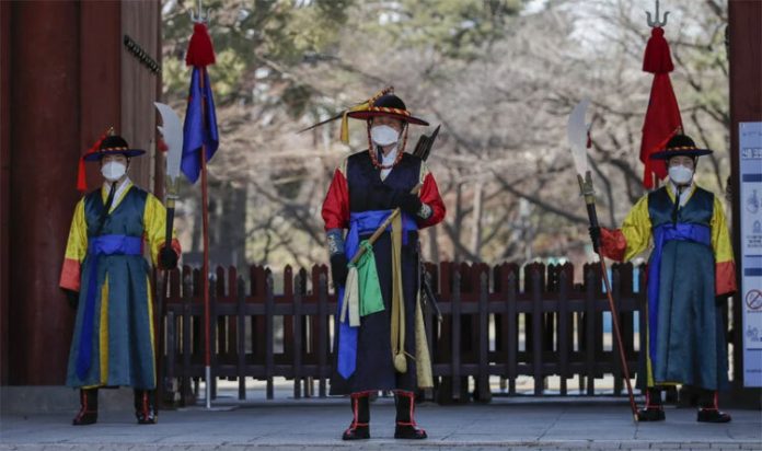 Nhân viên tại một điểm du lịch ở thủ đô Seoul, Hàn Quốc đeo khẩu trang trong những ngày đất nước đang bùng phát dịch nCoV. Ảnh: AP.