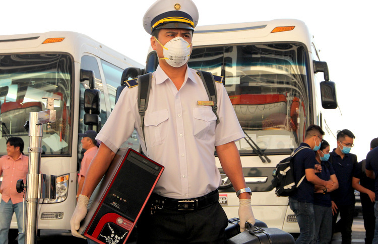 Nhân viên kiểm dịch y tế Nguyễn Hoài Trang mang máy lên tàu kiểm tra thân nhiệt du khách. Ảnh: Nguyễn Khoa.
