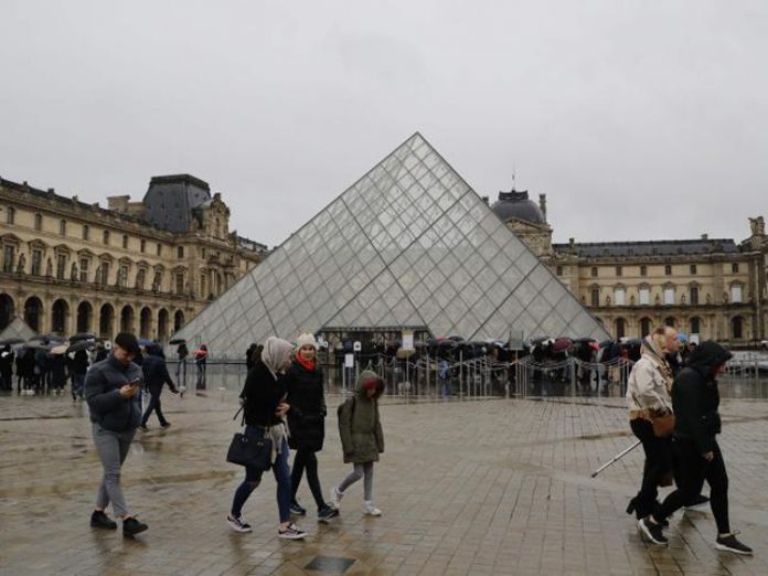 Du khách xếp hàng dài đứng đợi dưới mưa, rồi lại quay về vì bảo tàng không mở cửa vào sáng 1/3. Ảnh: AFP.
