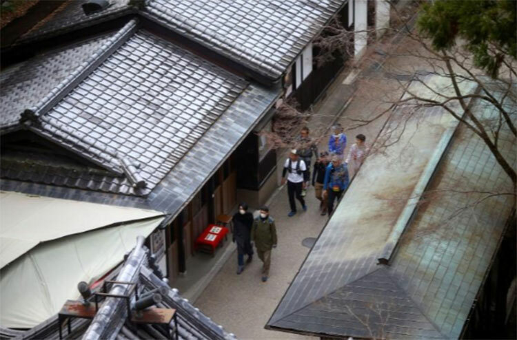 Một nhóm nhỏ du khách đi dạo trong khu vực đền Kyiomizu-dera ở Kyoto hôm 15/3. Ảnh: Reuters.
