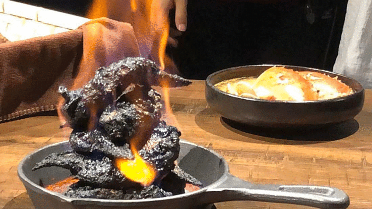 Thịt gà sau khi được ướp trong sữa đậu nành lên men truyền thống của Đài Loan sẽ được tẩm rượu và châm lửa để lớp da bên ngoài được cháy đen. Món gà rán đen xì biểu tượng cho hình ảnh của địa ngục. Ảnh: CNN. 