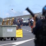 Tấn công khách du thuyền vì sợ nCoV Đoàn người biểu tình ném đá, chai lọ. Ảnh: Richard Bouhet/AFP.