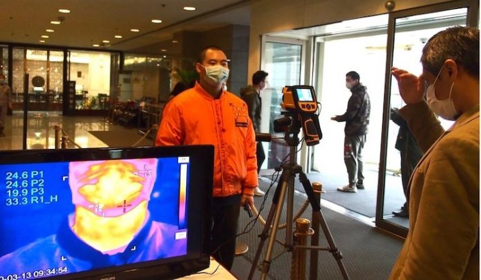 Khách tham quan đo thân nhiệt khi vào Bảo tàng Thượng Hải ngày 13/3. Ảnh: Xinhua.