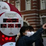 Du lịch Nhật đình trệ vì hoãn Olympic Người dân chụp ảnh với đồng hồ đếm ngược Olympic 2020, hiển thị ngày giờ hiện tại bên ngoài ga Tokyo. Đại dịch coronavirus đã buộc phải hoãn Thế vận hội. Ảnh: Jae C Hong / AP