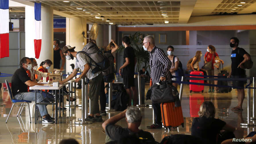 Những du khách Pháp mắc kẹt tại Bali làm thủ tục tại sân bay quốc tế Ngurah Rai, trước khi lên chuyến bay charter về nước vào ngày 28/3. Ảnh: Reuters.