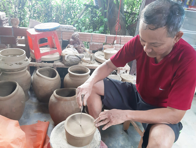 Ông Lê Quốc Tuấn với sản phẩm mới ở làng gốm Thanh Hà Ảnh: H.T