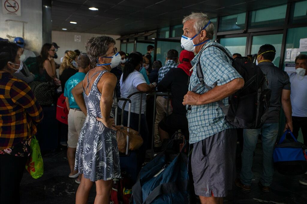 Du khách chờ đợi tại sân bay quốc tế La Aurora ở Guatemala vào ngày 24/ 3 trong một chuyến bay thuê bao được điều phối bởi Đại sứ quán Mỹ. Ảnh: Moise Castillo/AP.